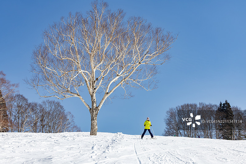一位女性在冬季假期中享受滑雪。图片素材