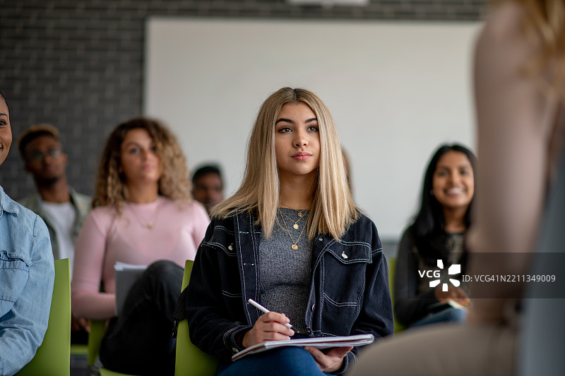 多元化的学生群体在现代教室环境中专心听讲图片素材