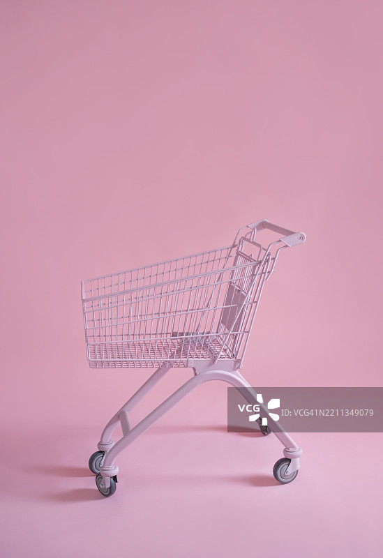 粉色购物车在粉色背景的工作室里图片素材