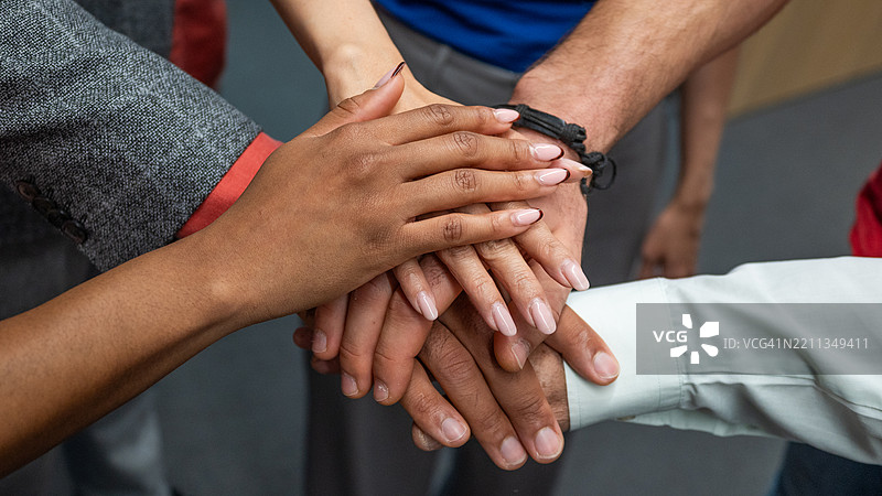 多元团队在协作办公环境中叠放的手图片素材