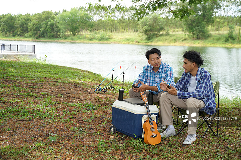 一个男人和他的朋友在假期去自然公园露营。图片素材