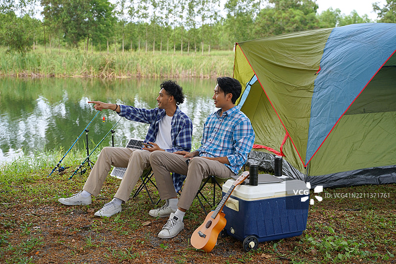 一个男人和他的朋友在假期去自然公园露营。图片素材