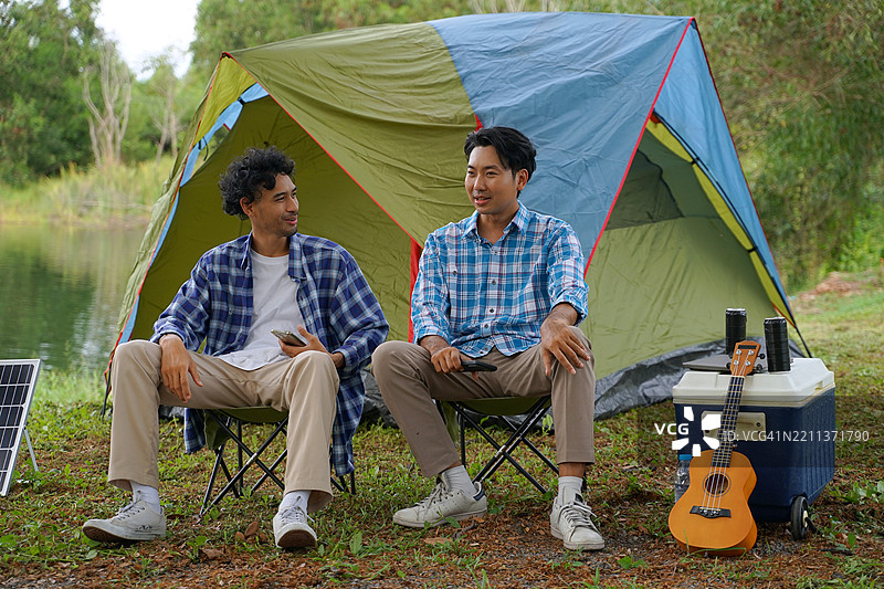 一个男人和他的朋友在假期去自然公园露营。图片素材