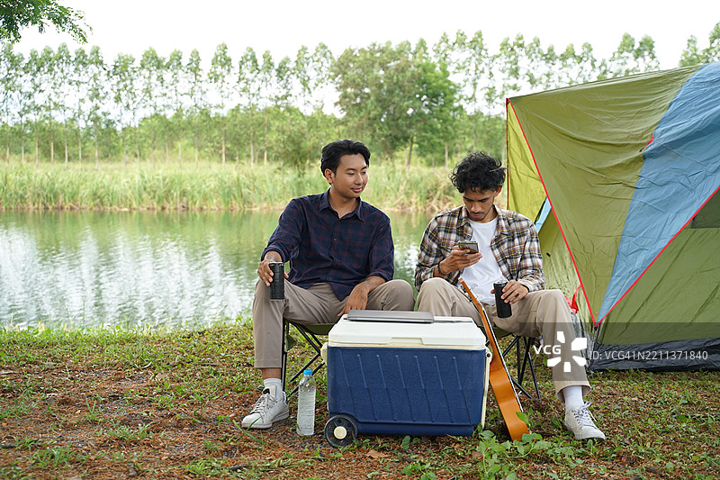一个男人和他的朋友在假期去自然公园露营。图片素材