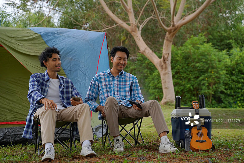 一个男人和他的朋友在假期去自然公园露营。图片素材