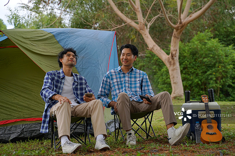 一个男人和他的朋友在假期去自然公园露营。图片素材