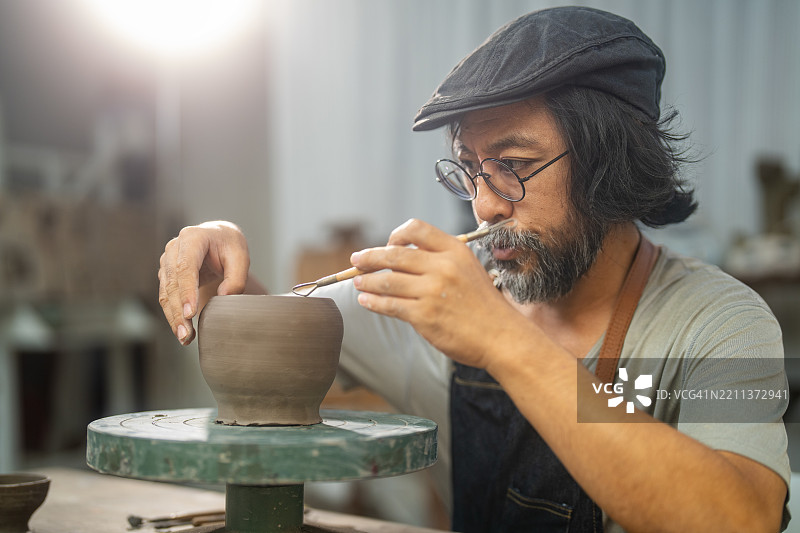 艺术家在工作室中用旋转的陶轮制作陶罐图片素材