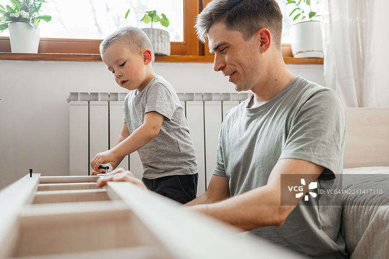 父亲和儿子在家里亲手组装家具图片素材