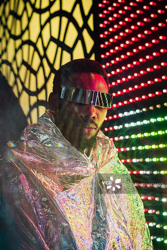 一幅未来主义风格的非裔美国男性肖像，他戴着反光护目镜，身披金属斗篷。图片素材