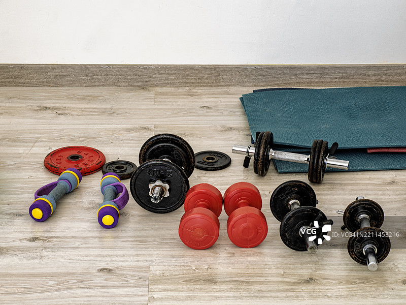 家用健身房中用于训练的不同类型的哑铃。图片素材
