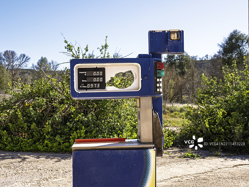 废弃加油站内一台屏幕损坏的旧加油泵。图片素材