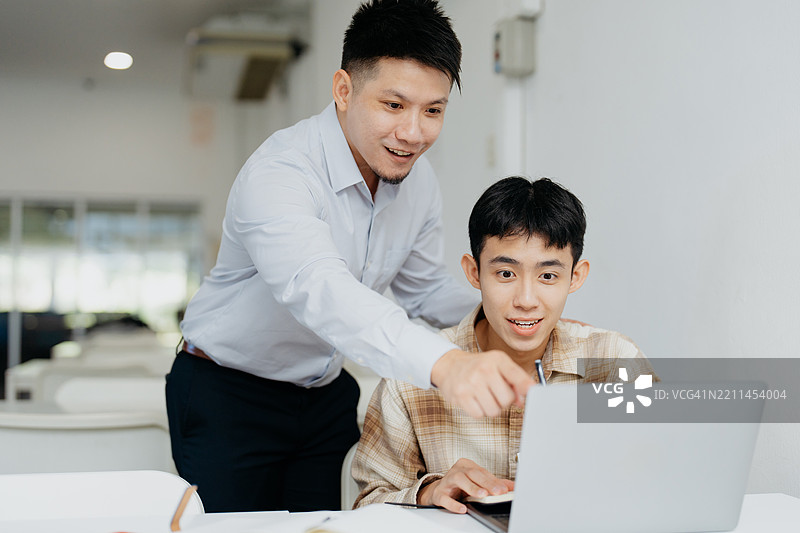 亚洲导师通过讲解课程和解答疑问来帮助他的学生图片素材