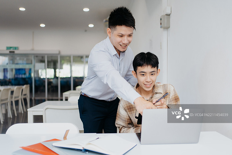 亚洲导师通过讲解课程和解答疑问来帮助他的学生图片素材