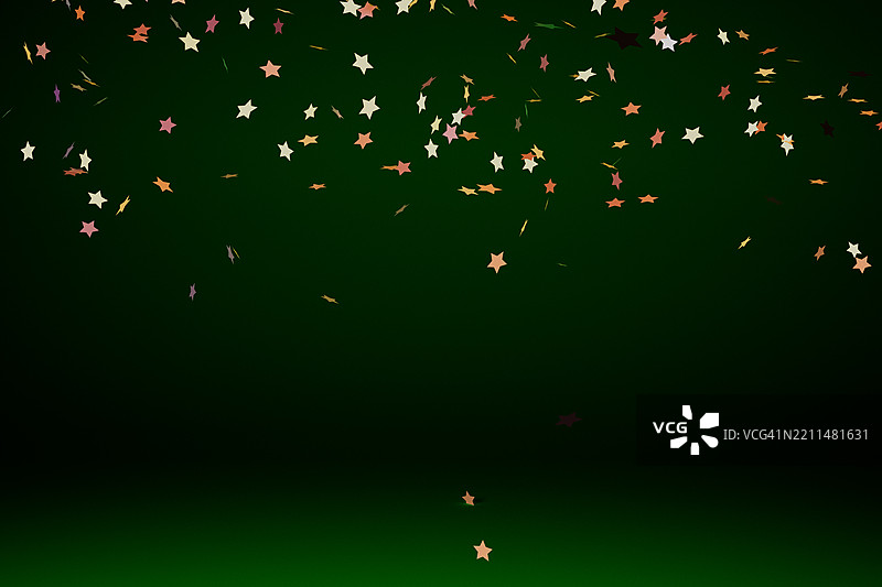 绿色背景上的飘落彩色星星图片素材