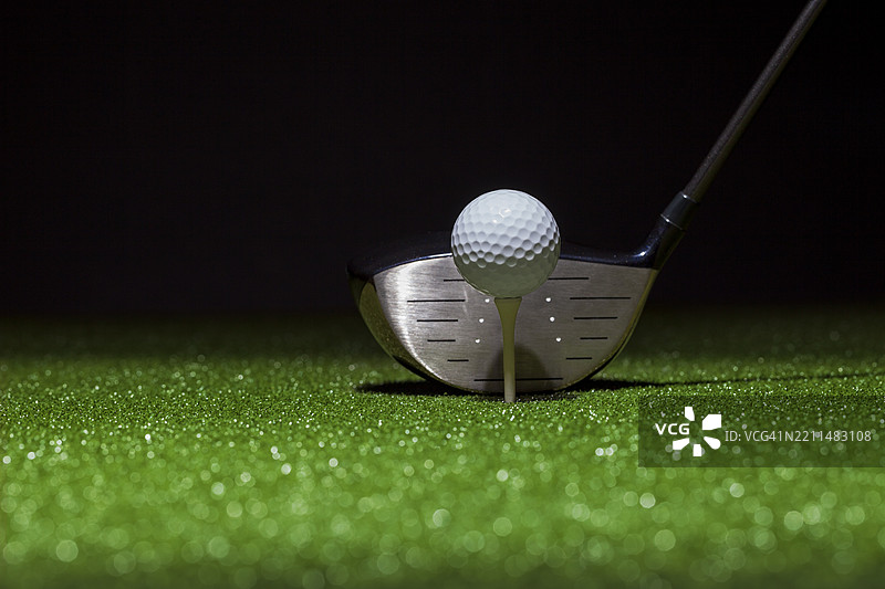 低角度选择性聚焦的高尔夫球和球杆，背景为黑色，地点：美国明尼苏达州图片素材