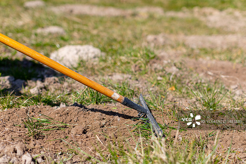 新翻耕土壤中放置的锄头，准备种植和生长的详细图像图片素材
