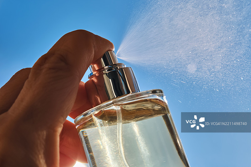 手握瓶子，背景为蓝色图片素材