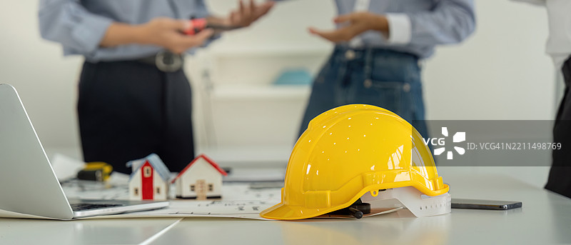 项目讨论与安全装备，一个象征性的建筑安全帽图片素材