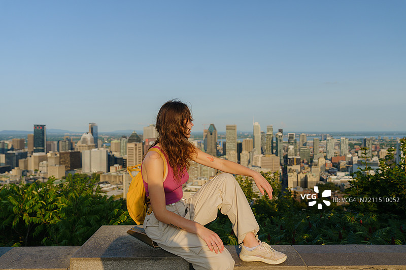 夏天，一位女性在皇家山上俯瞰蒙特利尔的城市风景图片素材