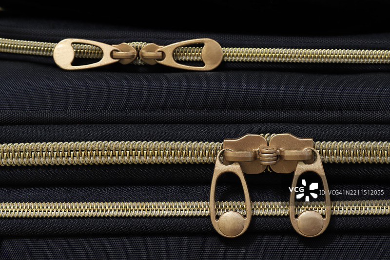 软壳行李上的金属拉链，展示了滑块和拉环图片素材