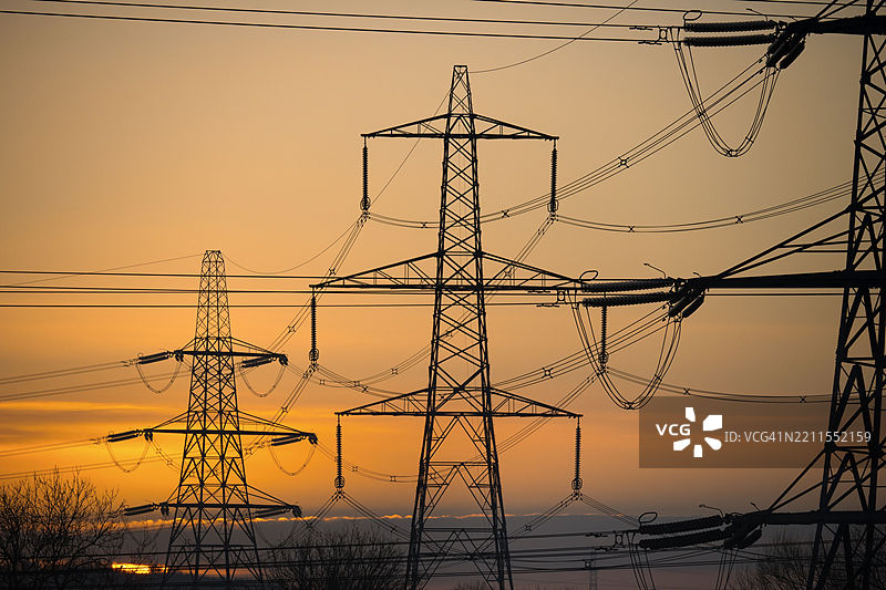 肯宁顿草地上的巨型电塔，映衬着辉煌的冬季日出图片素材
