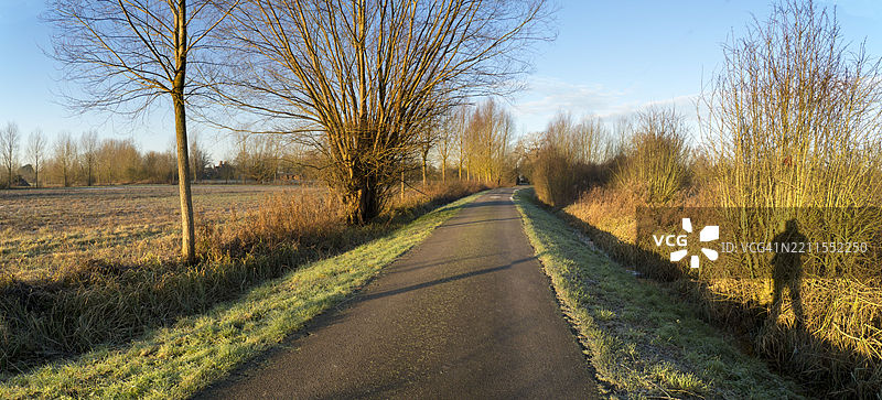 泰晤士河和拉德利村船屋旁的人行道上长长的阴影，寒冷的冬日日出图片素材