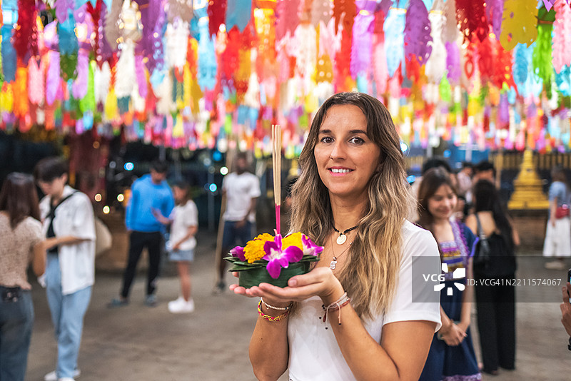 微笑的年轻女性在泰国的水灯节上手持祭品。图片素材