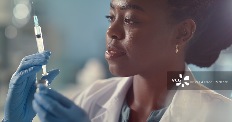 医疗、医学和一位手持注射器的黑人女性在实验室进行研究、医学研究和临床试验。医院、制药公司和医生为疫苗、发现和突破进行注射。图片素材