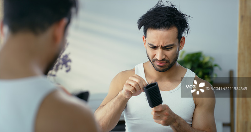 沮丧的男人，镜子或梳子与糟糕的发型日，美容灾难，护理不当或在家失败。失落、生气或男性与反射，头发断裂或头皮问题因使用错误的洗发水。图片素材