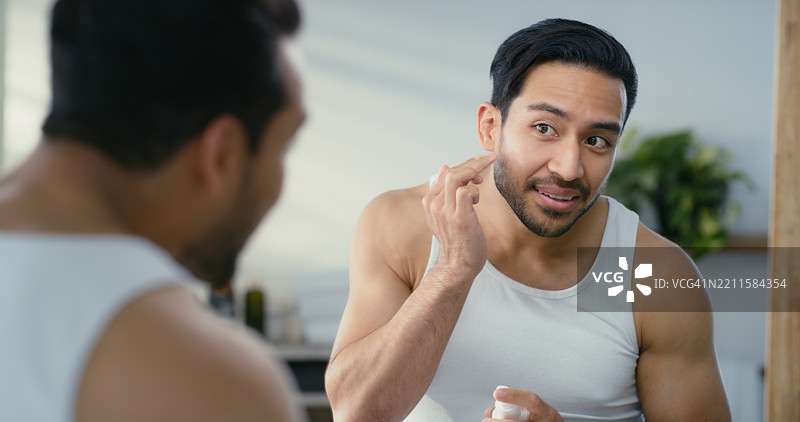 男士、润肤露和镜子，配合面霜用于护肤、修饰或晨间护理，家中的浴室。快乐的男性或微笑着使用保湿霜进行面部护理、皮肤科或美容。图片素材