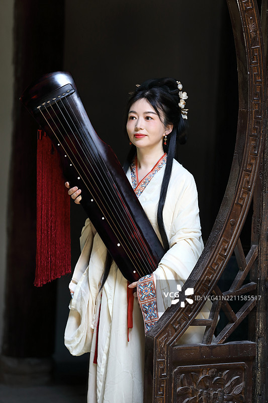 一位身穿汉服的年轻中国女子手持古琴图片素材