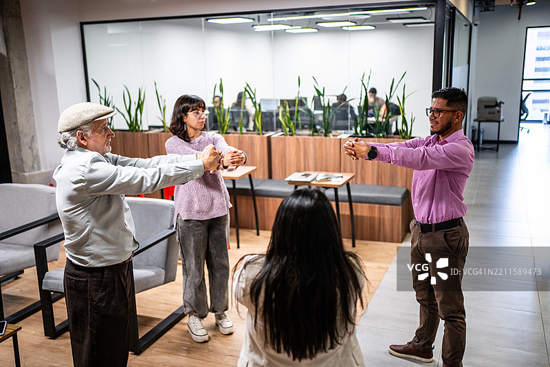 同事们在办公室伸展身体图片素材