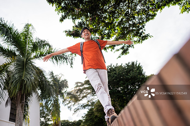 年轻女性在城市中张开双臂行走图片素材