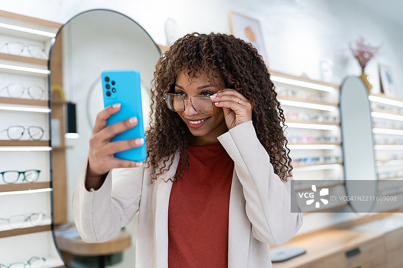 顾客在眼镜店里用新眼镜自拍图片素材