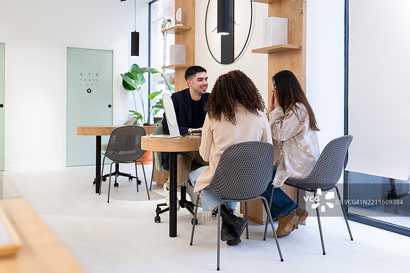 验光师在眼镜店帮助顾客选择眼镜图片素材