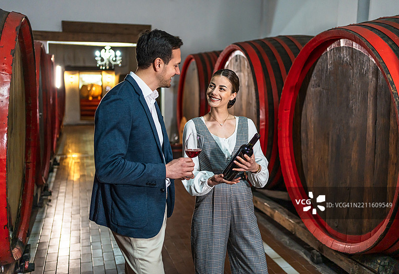 酒类专家在酒窖中品尝橡木桶中的葡萄酒图片素材