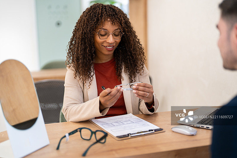 验光师在眼镜店帮助顾客选择眼镜图片素材