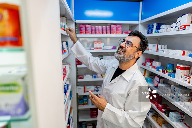 成熟的药剂师在药店寻找药物图片素材