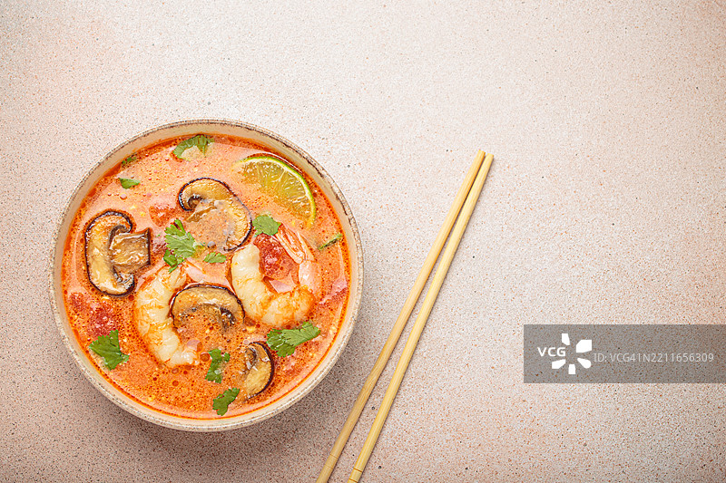 虾菇冬阴功汤盛在碗中，旁边有筷子。图片素材