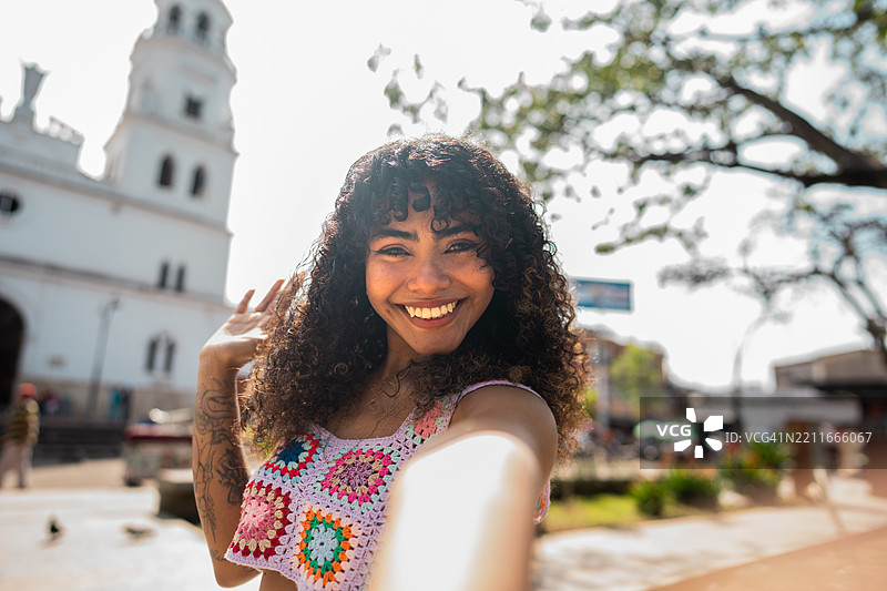 年轻女性在哥伦比亚布卡拉曼加的历史区自拍 - 摄影机视角图片素材
