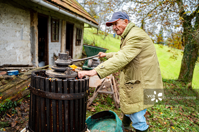 老年人在户外使用传统的苹果酒压榨机图片素材