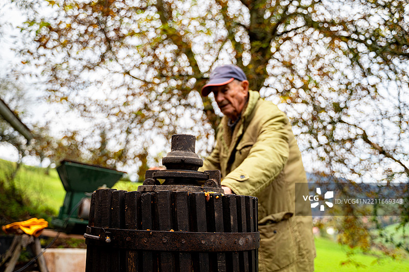 老年人在户外使用传统的苹果酒压榨机图片素材