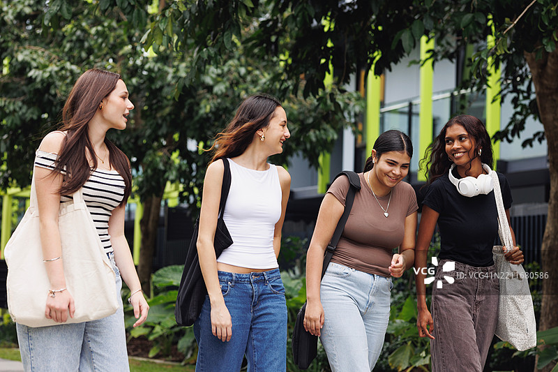 四名大学生在校园内散步，组成多元化的团队图片素材