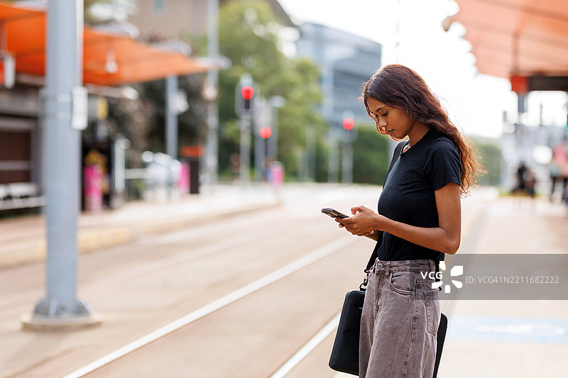 年轻的澳大利亚土著女性在城市火车站等候的肖像图片素材