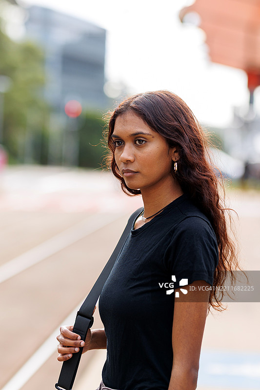 年轻的澳大利亚土著女性在城市火车站等候图片素材
