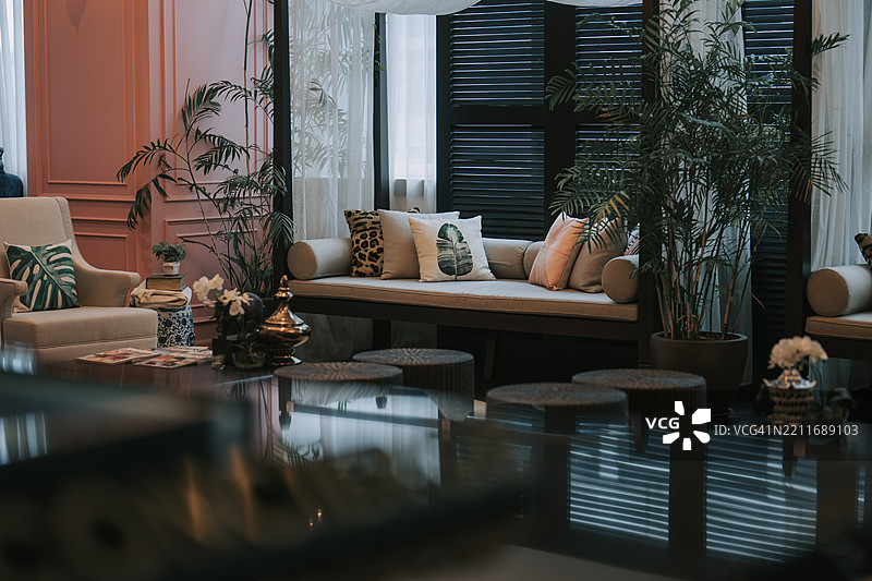 时尚的热带风格休息区，配有室内植物和舒适的座椅图片素材