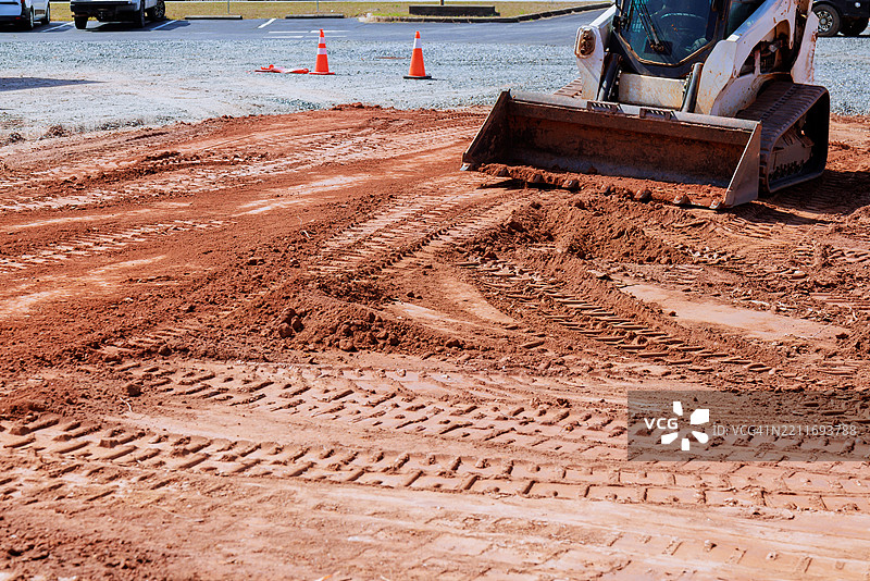 施工车辆在白天的工地上平整地面图片素材