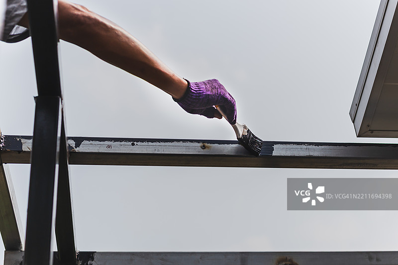 在家中为装饰钢材手工涂抹防锈漆图片素材