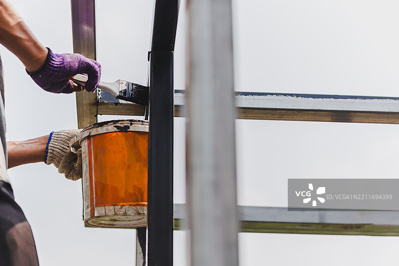 在家中装饰的钢材上涂抹防锈漆的男子图片素材