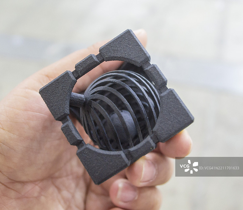 手中握着3D打印的塑料模型的人图片素材
